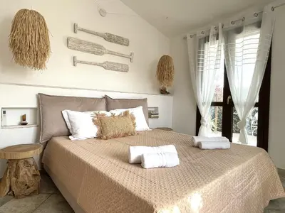 Letto o letti in una camera di Villa Allegria, romantic luxury 300m from the beach, heated pool, firepit and sauna