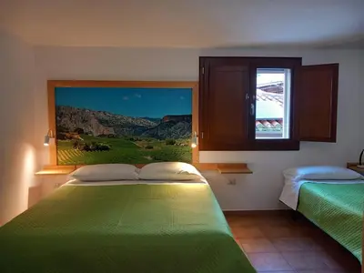 Letto o letti in una camera di AFFITTACAMERE DORGALI B&B da ZIETTO