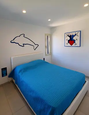 Letto o letti in una camera di Appartamento delfino azzurro
