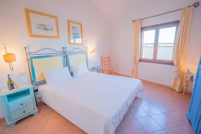 Letto o letti in una camera di residence baia sant anna con piscina